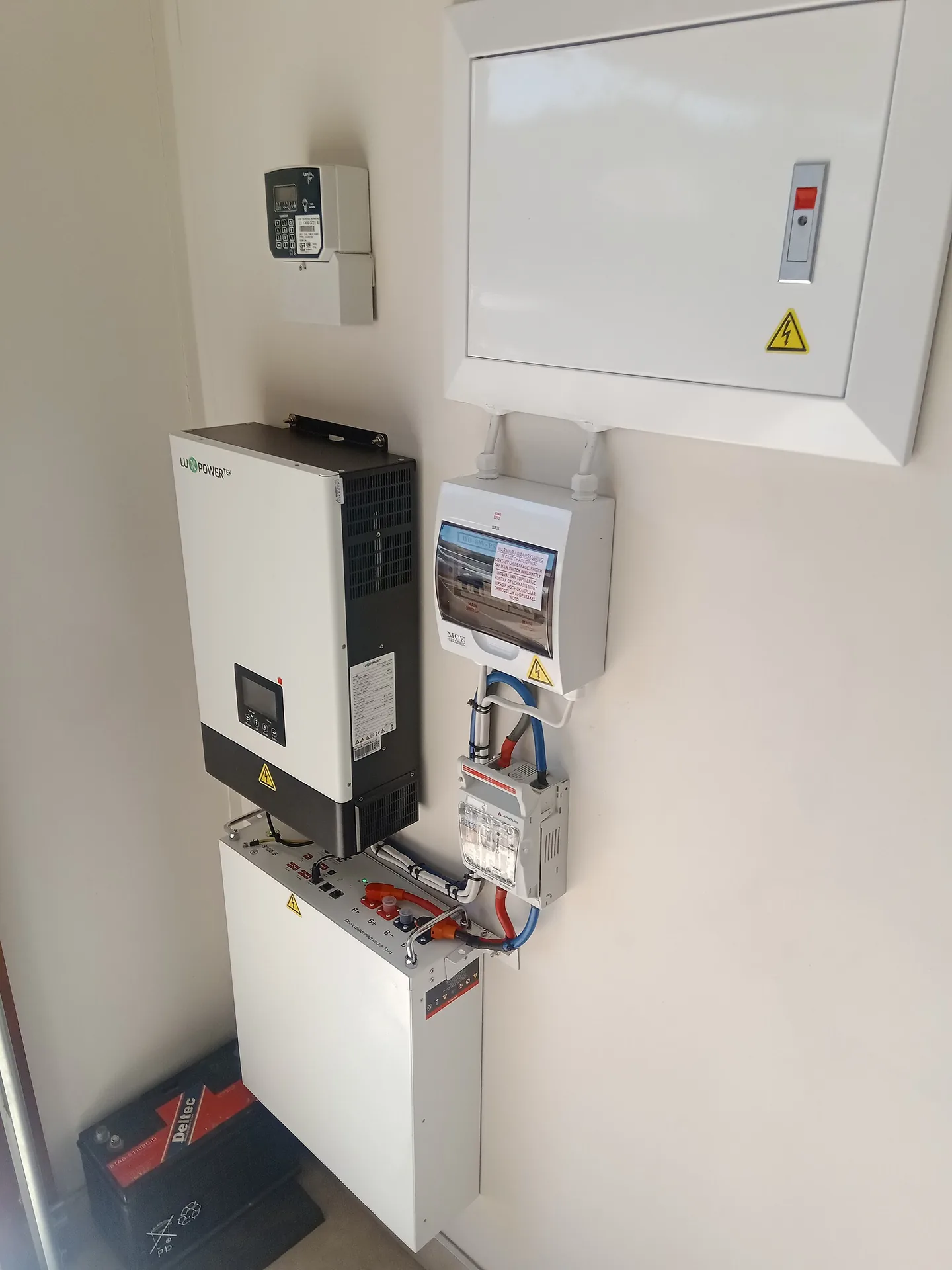 Een aan de wand gemonteerde batterij en omvormer als installatievoorbeeld, niet een getest product.